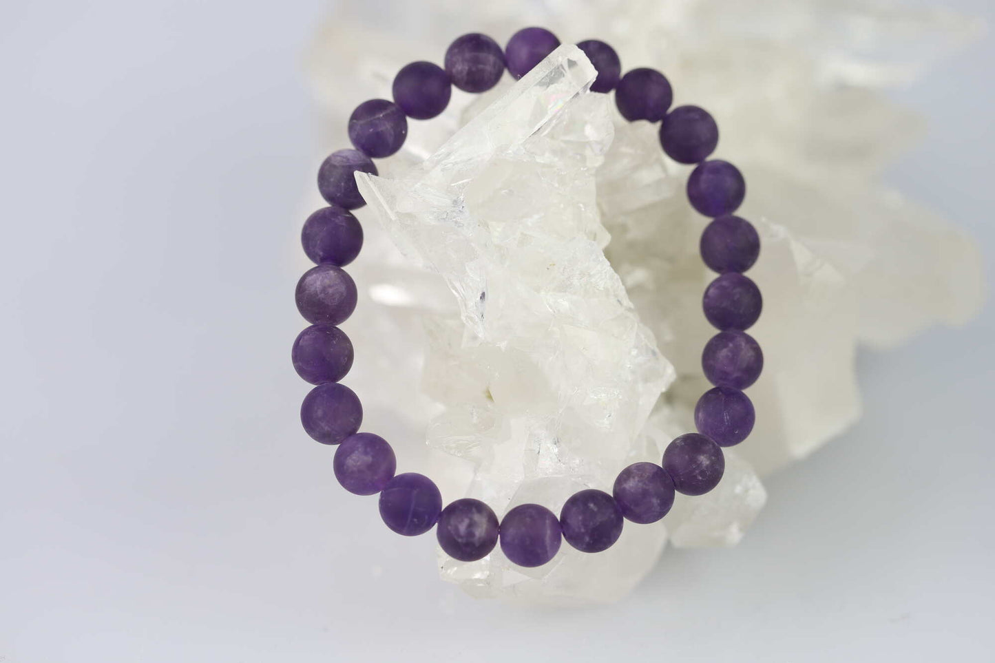 Kristallwerk präsentiert: Armband mit matten Amethyst Kugeln auf einer Bergkristall Stufe.