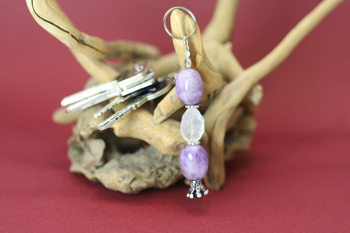 Kristallwerk präsentiert einen Schlüsselanhänger mit polierten Amethyst Nuggets und facettierten Bergkristall in Eiform und filgranen Zwischenstücken.