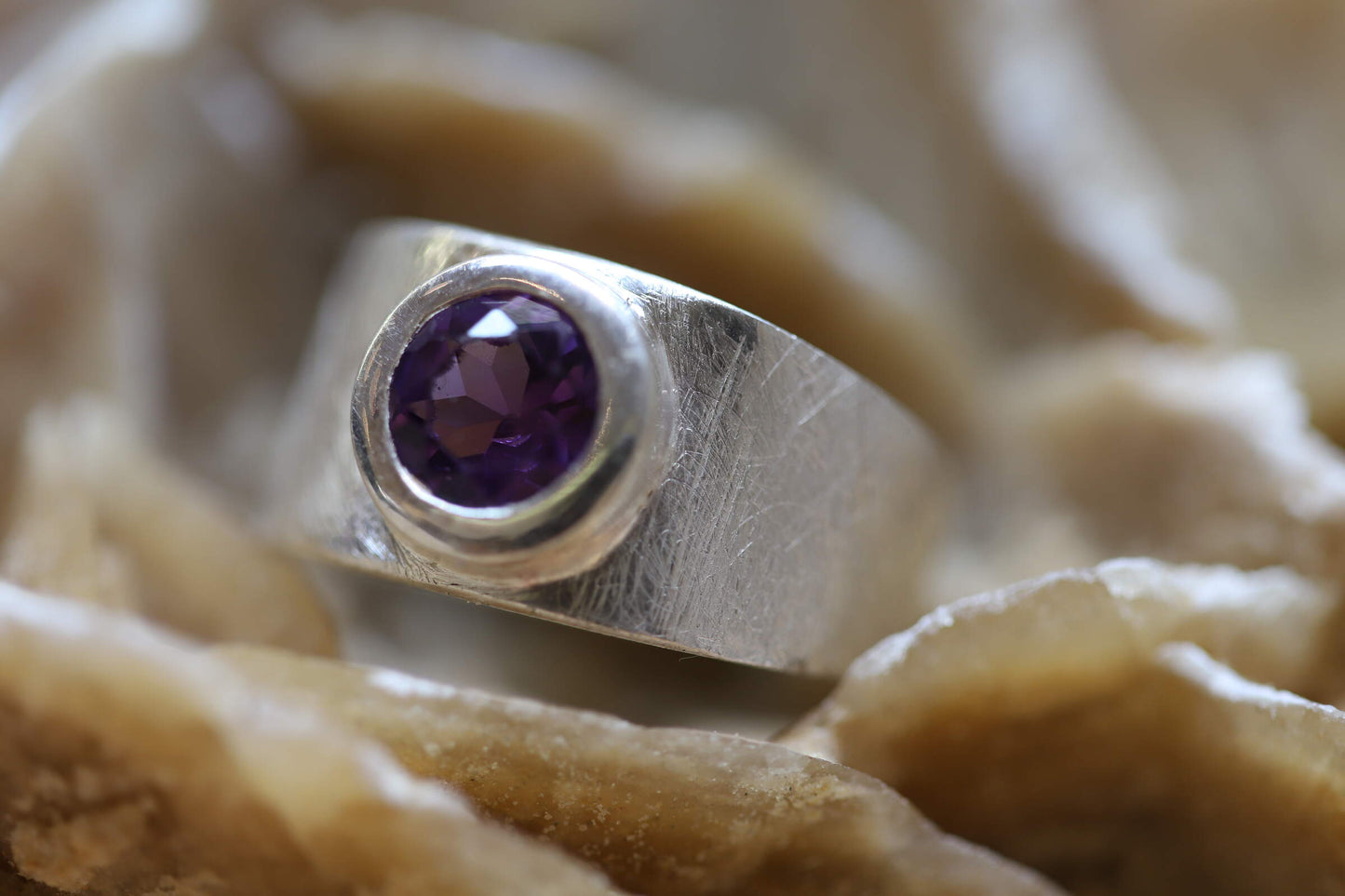 Ring aus Silber 925 satiniert mit einem facettierten und leuchtenden Amethyst