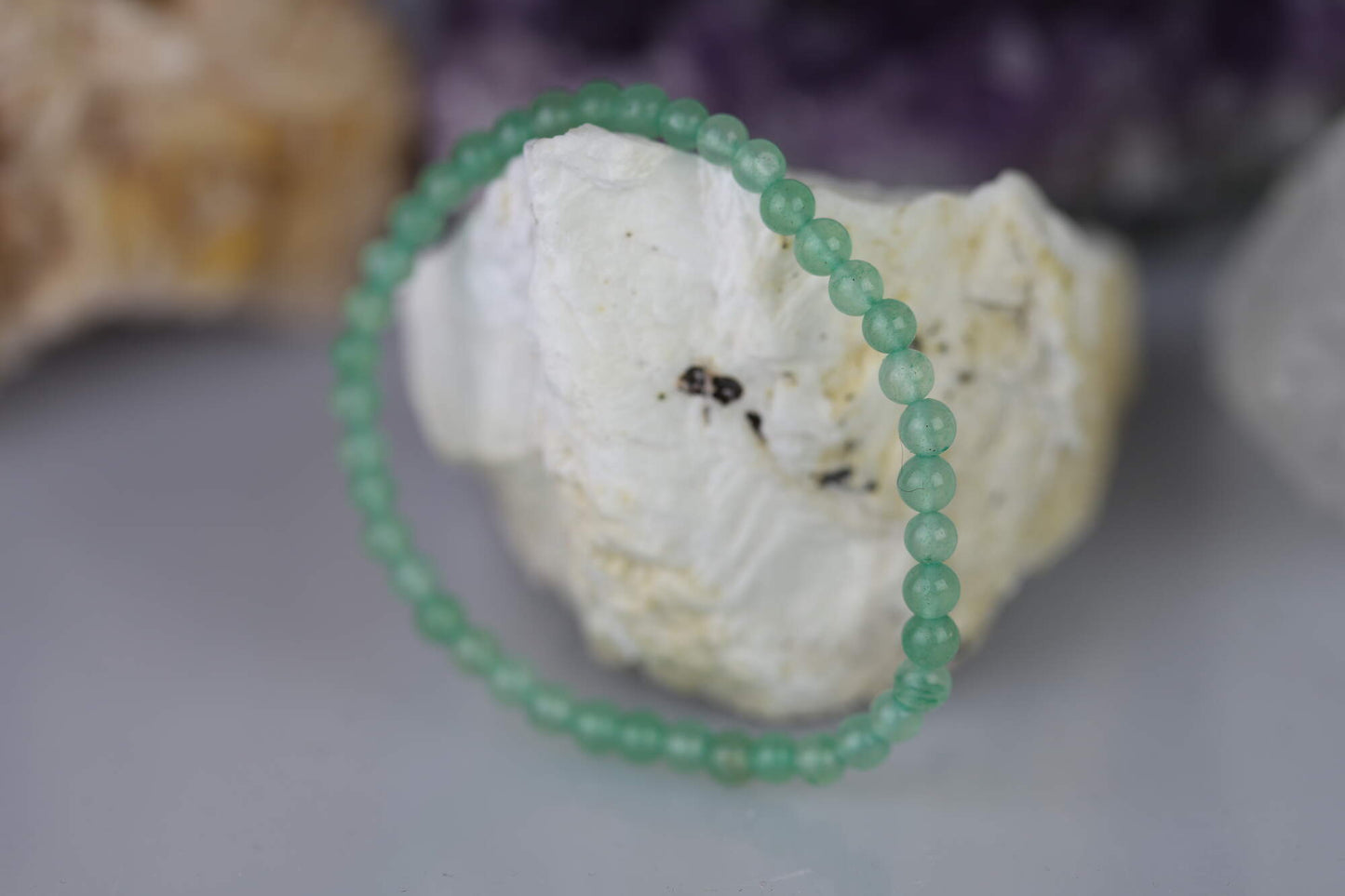 Kristallwerk präsentiert: Armband mit Aventurin Kugeln auf einem weissen Barytstein.