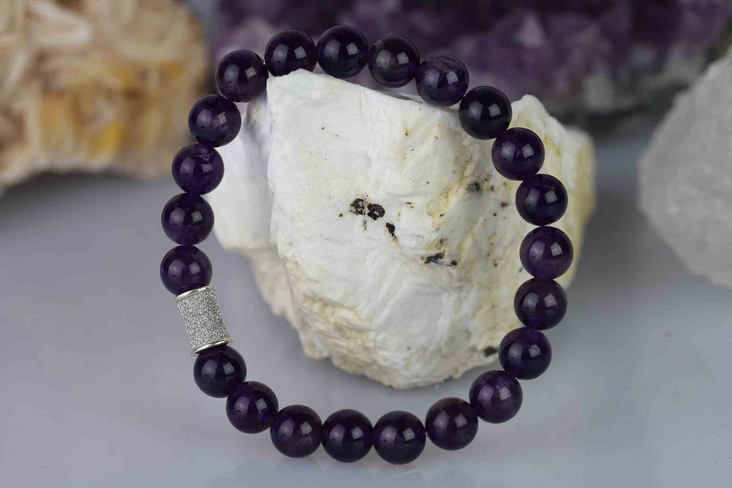 Kristallwerk präsentiert: Armband mit glänzenden Amethyst Kugeln und mit einem eingesetzten Silberstück.