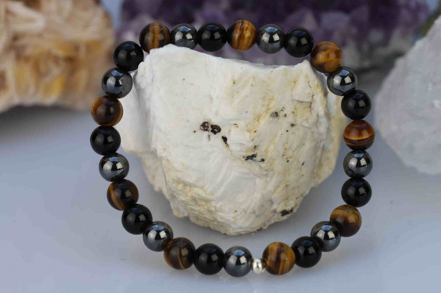 Kristallwerk präsentiert: Ein Power-Armband aus polierten Onyx, Tigerauge und Hämatit Kugeln mit einem zusätzlichen Silberzwischenstück auf einem Barytstein.