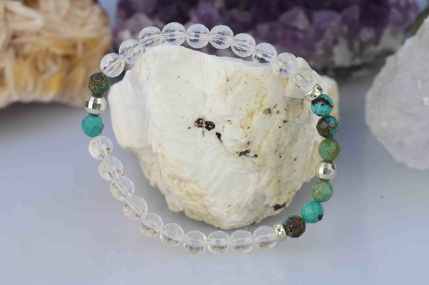 Kristallwerk präsentiert: Armband aus facettierten Türkis natur und Bergkristall Kugeln mit zusätzlichen Silberkugeln auf einem Barytstein.