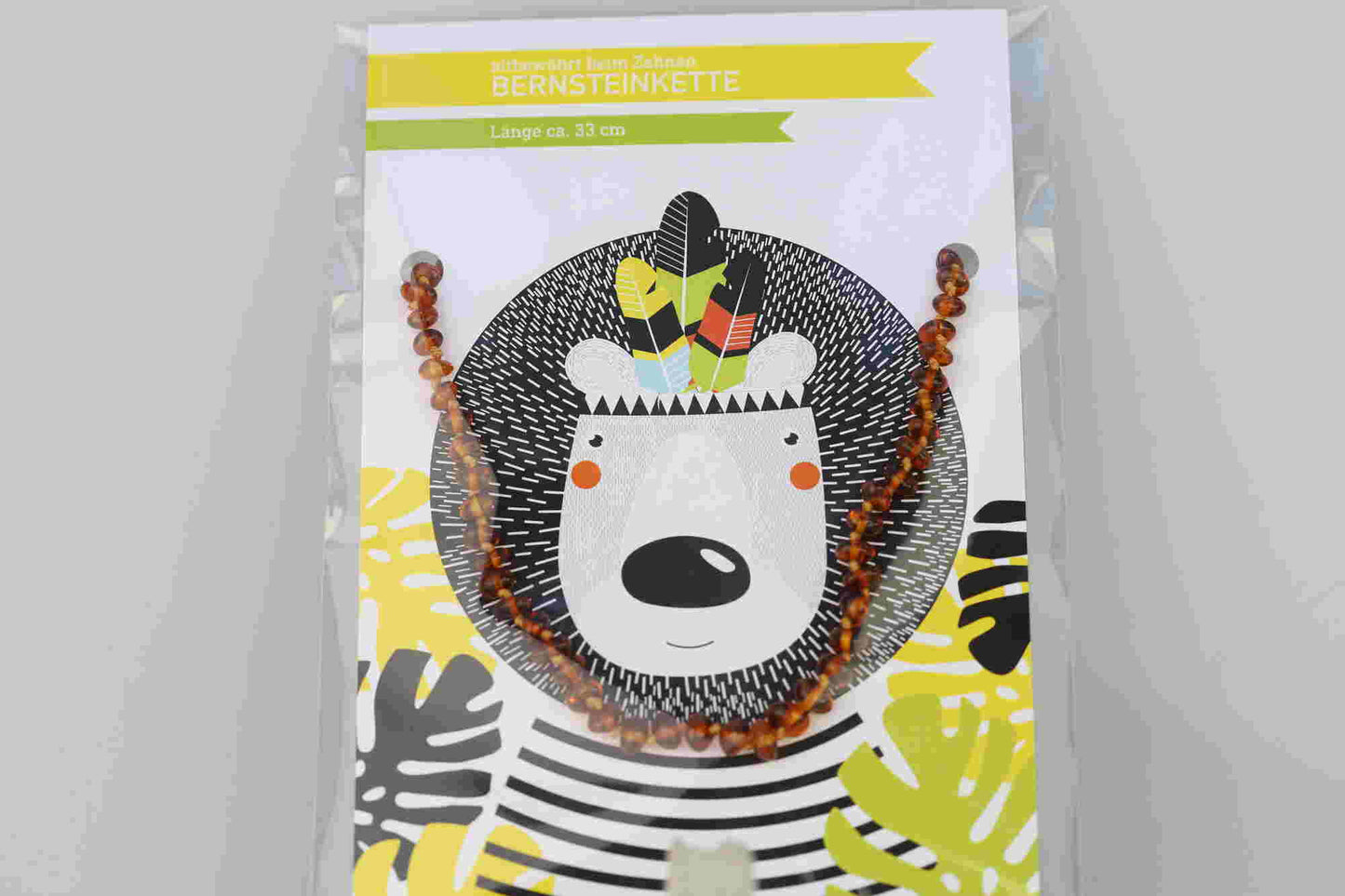 Kristallwerk präsentiert: Bernsteinkette für Bäbys auf einer Geschenkskarte eingepackt und mit einem Tierdesign versehen.