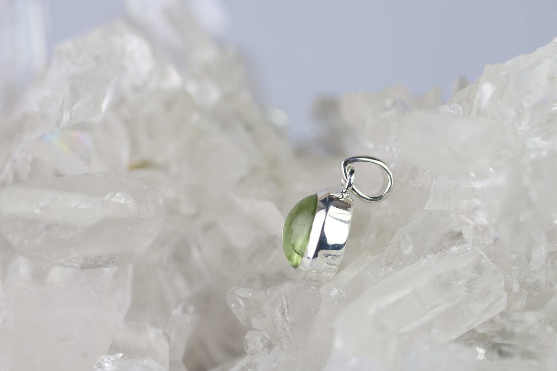 Kristallwerk präsentiert: Anhänger geschliffener Peridot Cabochon in Silber 925 gefasst auf einer Bergkristall Stufe.