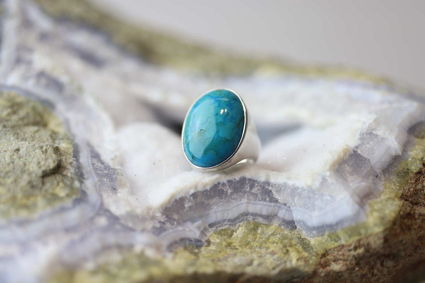 Kristallwerk präsentiert einen Ring aus Silber mit einem fantastischem und ovalem Türkis auf einer Chalcedongeode.