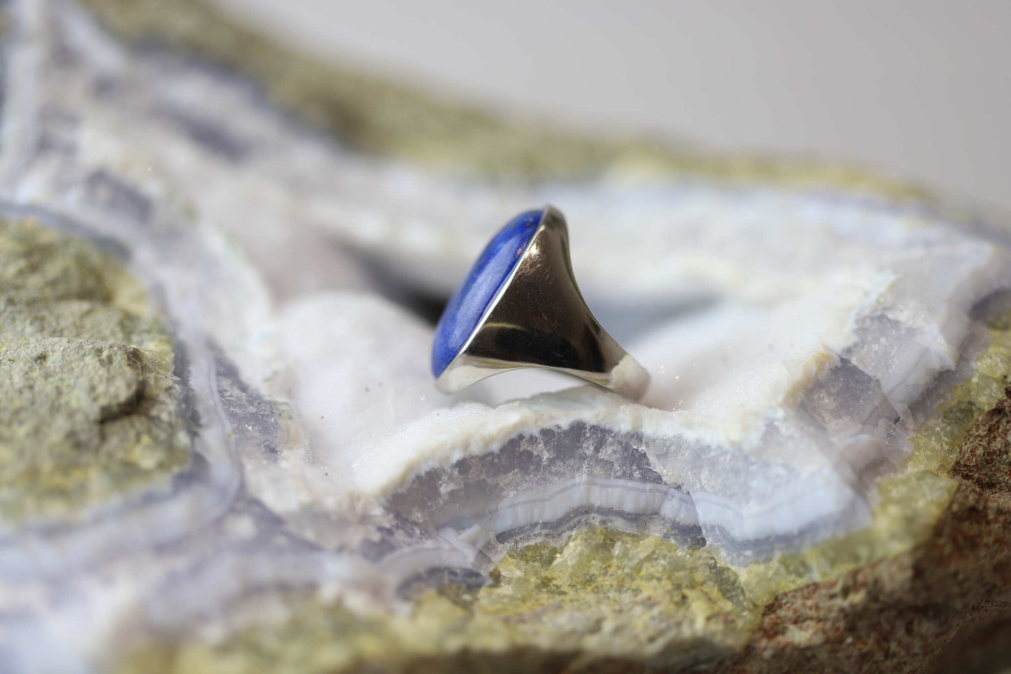 Kristallwerk präsentiert einen Ring aus Silber mit einem fantastischem und ovalem Lapislazuli auf einer Chalcedongeode.