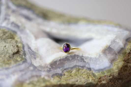 Kristallwerk präsentiert einen Ring aus Silber vergoldet mit einem facettiertem und ovalem Amethyst auf einer Chalcedongeode.