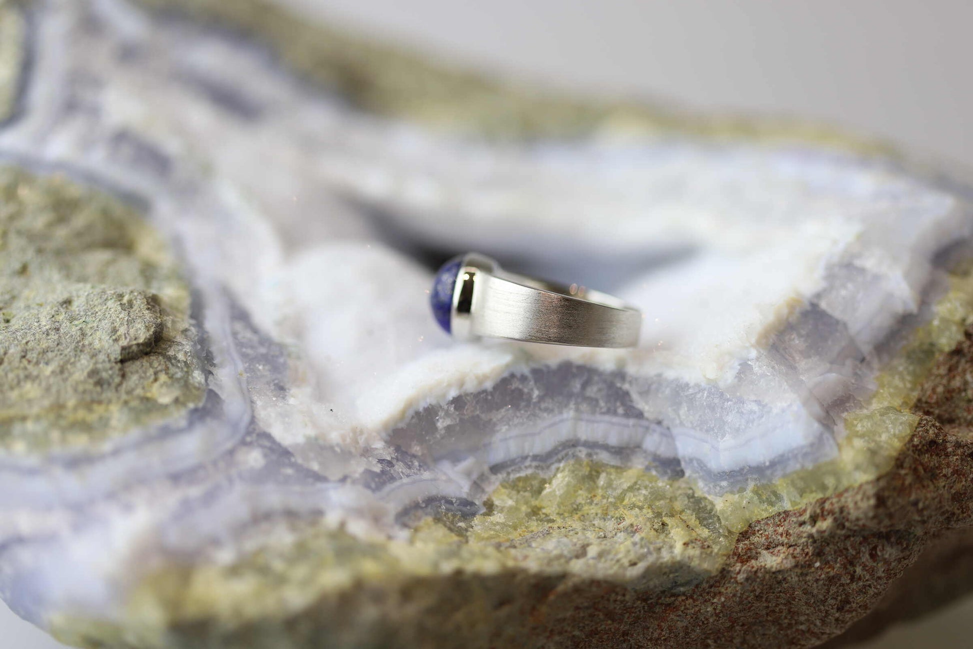 Kristallwerk präsentiert einen Ring aus Silber 925 mit einem polierten Lapislazuli Cabochon auf einer Chalcedongeode.