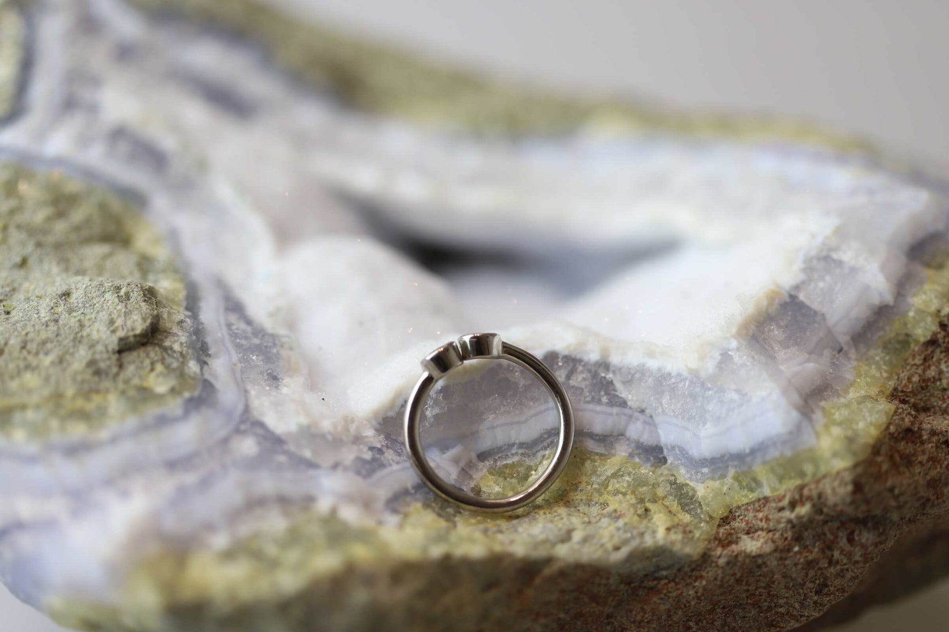 Kristallwerk präsentiert einen Ring aus Silber 925 mit zwei facettierten goldgelben Citrinen auf einer Chalcedongeode.