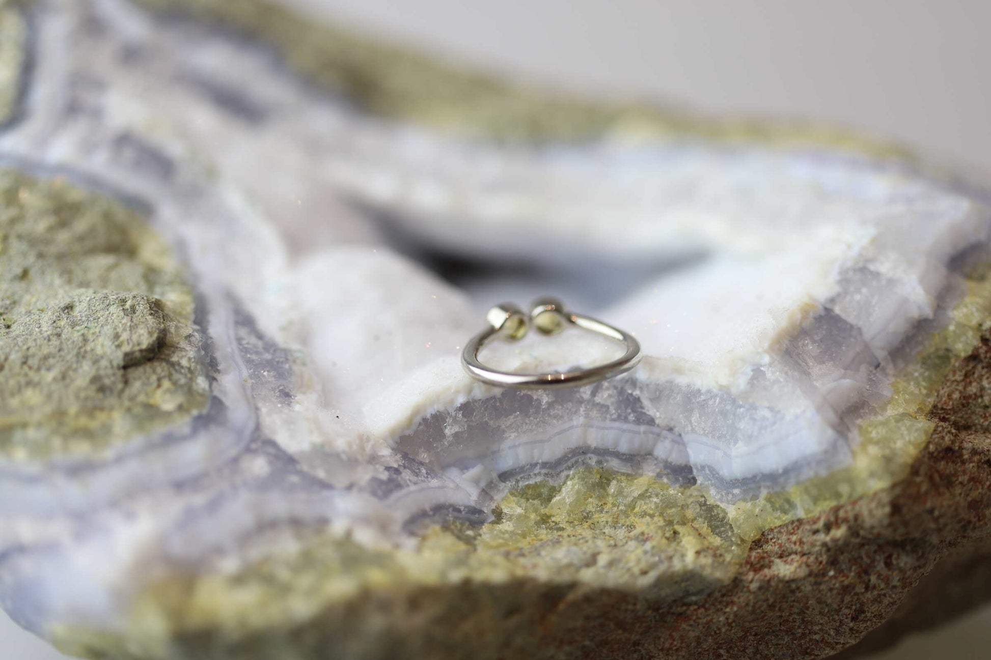 Kristallwerk präsentiert einen Ring aus Silber 925 mit zwei facettierten goldgelben Citrinen auf einer Chalcedongeode.