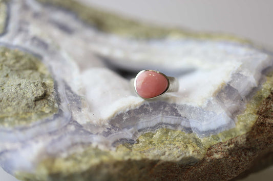 Kristallwerk präsentiert einen Ring aus Silber 925 mit einem polierten und pinken Opal auf einer Chalcedongeode.