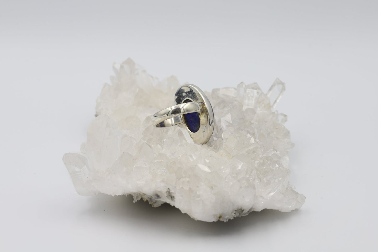 Kristallwerk präsentiert einen Ring aus Silber 925 mit einem polierten Lapislazuli Cabochon auf einer Bergkristallstufe