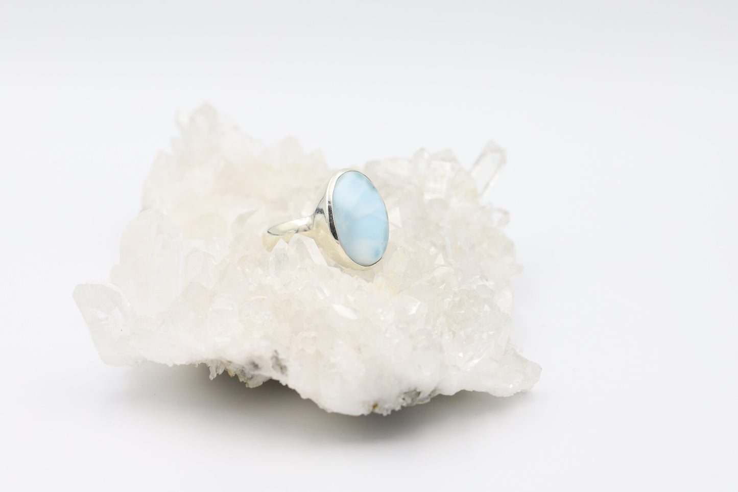 Kristallwerk präsentiert einen Ring aus Silber 925 mit einem polierten Larimar Cabochon auf einer Bergkristallstufe.