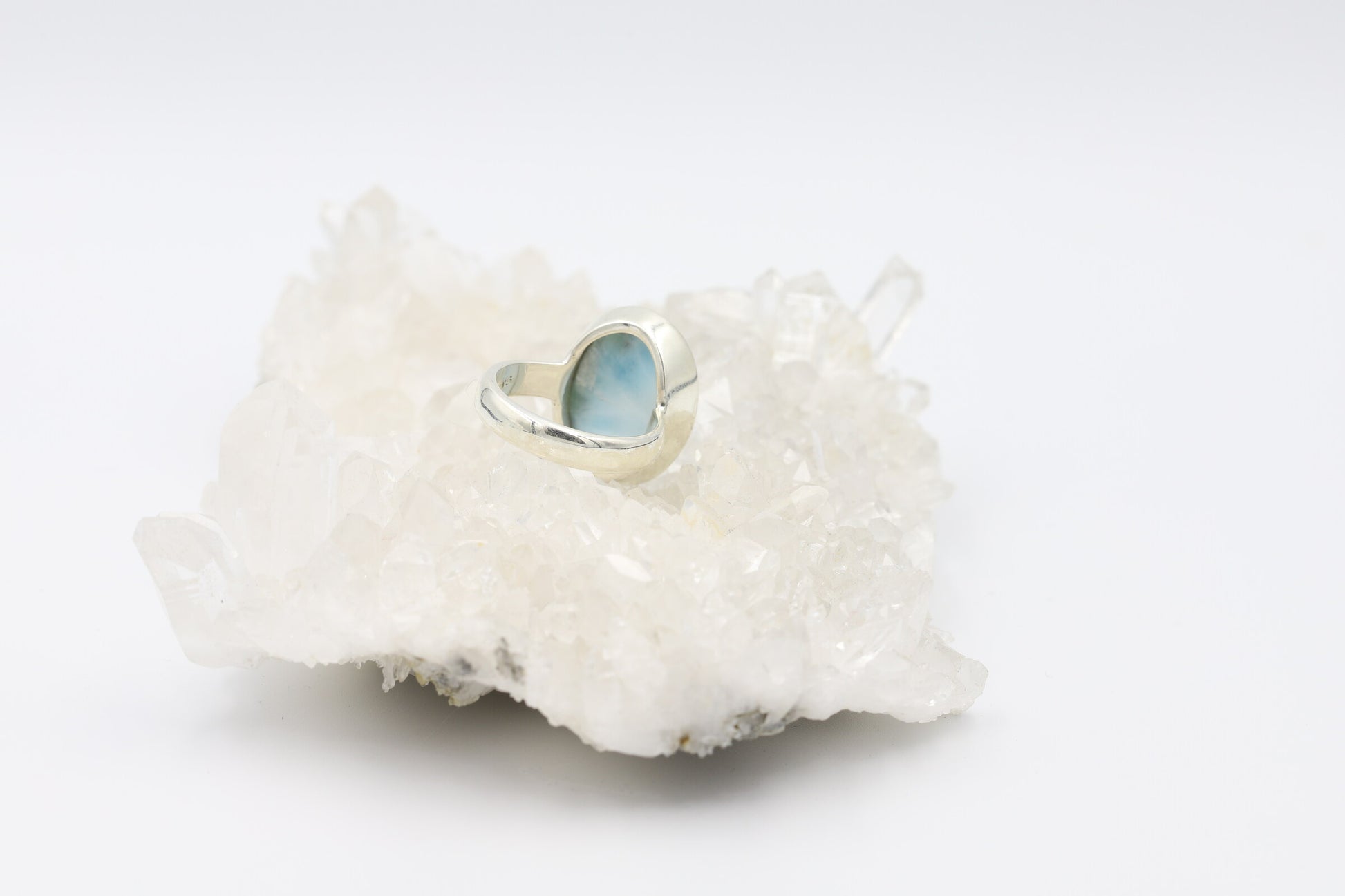 Kristallwerk präsentiert einen Ring aus Silber 925 mit einem polierten Larimar Cabochon auf einer Bergkristallstufe.