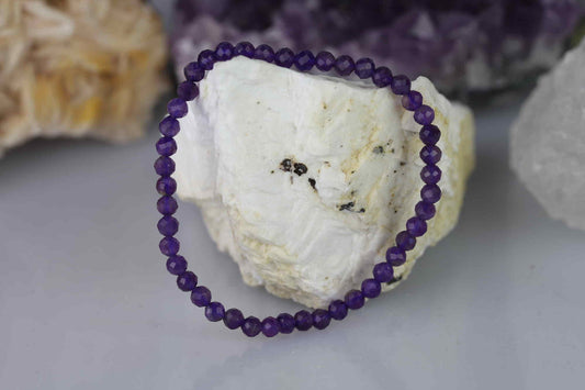 Kristallwerk präsentiert: Armband aus facettierten Amethyst Kugeln. Aufgelegt auf einem weissen Barytstein.